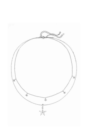 Collana a strati tono argento con due catene delicate, pendente a forma di stella e piccoli accenti a forma di stella lungo i fili.