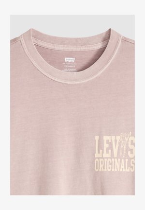 Jasnoróżowa koszulka Levi's Originals z okrągłym dekoltem, vintage fit, z logo i grafiką na piersi, wykonana w Pakistanie.