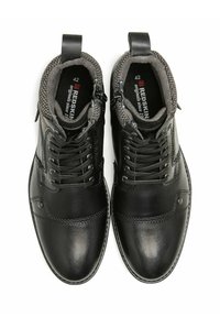 Bottes basses en cuir noir avec doublure grise texturée, design à lacets et zips latéraux. Caractérisées par des coutures décoratives et un bout rond.