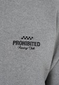 Szary sweter dzianinowy z wyhaftowanym tekstem "PROHIBITED Racing Club" w czerni. Charakteryzuje się teksturowaną tkaniną oraz szachownicowymi akcentami nad napisem.