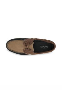 Zapato de barco de cuero marrón y beige con punta redondeada, parte superior con cordones, costuras en contraste y suela de goma negra. Marca Kaporal Jeans visible.