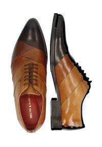 Zapatos de cuero marrón con punta afilada, que presentan paneles texturizados en diferentes tonos, cordones y un tacón negro. El interior tiene un forro rojo.