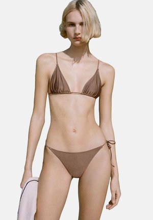 Ensemble de bikini marron comprenant un haut triangulaire avec de fines bretelles et un bas taille basse assorti avec des liens sur les côtés. Texture lisse et design minimaliste.