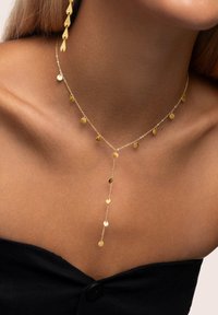 Collana in tono oro con una delicata catena che presenta numerosi piccoli pendenti rotondi e un elemento centrale pendente, che ne esalta l'aspetto a strati.