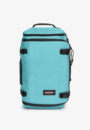 Turquoise backpack with black accents, made of durable fabric. Features a front mesh pocket, top handle, and adjustable straps.