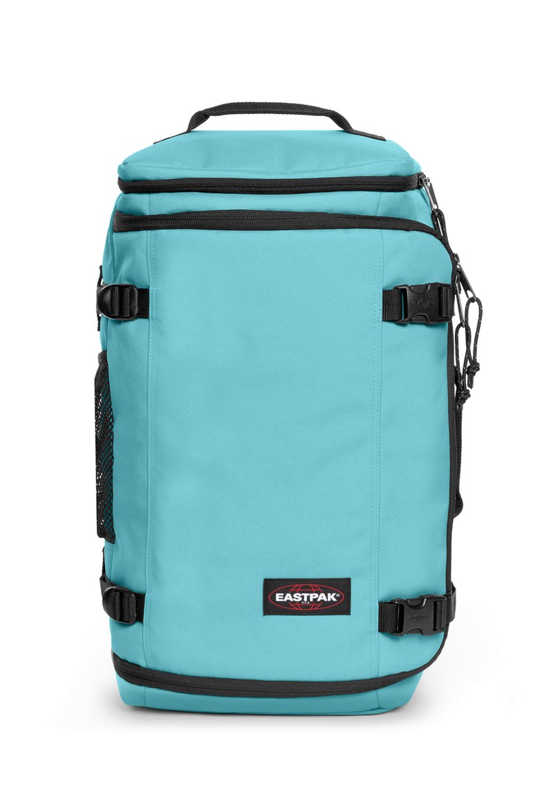 Sac à dos turquoise avec des accents noirs, fabriqué en tissu durable. Dispose d'une poche frontale en mesh, d'une poignée supérieure et de bretelles réglables.