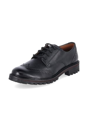 Zwarte leren veter brogue schoen met decoratieve perforaties en een robuuste rubberen zool, schuin weergegeven op een witte achtergrond.