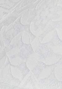 Tessuto bianco testurizzato con un motivo floreale, con sottili elementi in rilievo e diverse tonalità di bianco che creano profondità. Finitura morbida e liscia.