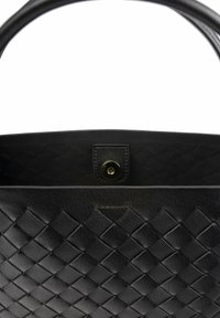 Sac à main en cuir tressé noir avec une texture lisse, doté d'une poignée supérieure et d'une fermeture à pression. L'intérieur est sans coutures et spacieux.