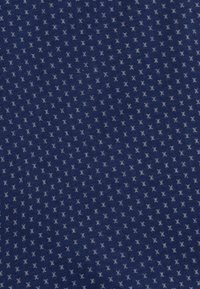 Granatowy materiał o prążkowanej fakturze z małymi, jasnoszarymi wzorami geometrycznymi równomiernie rozmieszczonymi w całej powierzchni.