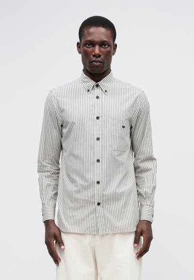 Stripet langermet skjorte i hvit og mørk blå, med knappedekollet, brystlomme og teksturert stoff.