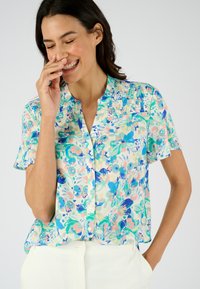 Korte mouwen, blouse met kraag van een lichtgewicht stof met een bloemenpatroon in groene, blauwe en roze tinten; geplooide halslijn.