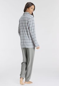 Striped grey pullover with long sleeves paired with soft grey joggers. The texture appears smooth, and the design is relaxed fit.
