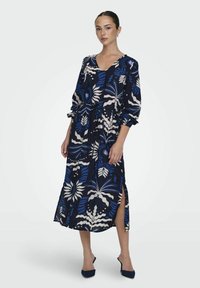Langes navy-blaues Kleid mit weißen und blauen Blumenmustern, V-Ausschnitt, elastischen Manschetten und Seitenschlitzen, aus leichtem Stoff gefertigt.