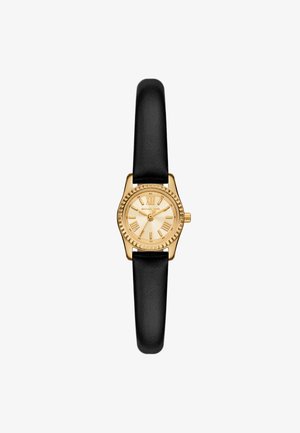 Montre-bracelet dorée avec un cadran rond et des chiffres romains, dotée d'une lunette texturée et d'un bracelet en cuir noir.