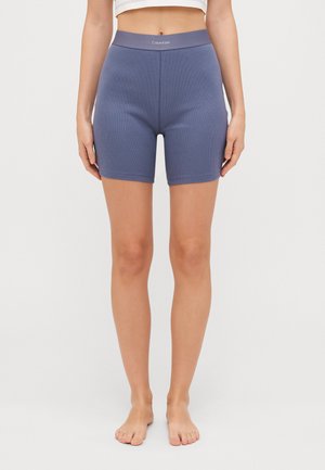 Gerippte, nahtlose, blaue Fahrradhosen mit einem elastischen Taillenbund, der das Calvin Klein-Logo trägt. Mittlere Oberschenkellänge, weiche Textur.