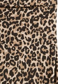 Leopardmönstrad tyg med mörkbruna och beige fläckar mot en ljusbrun bakgrund, med en mjuk textur och slät yta.
