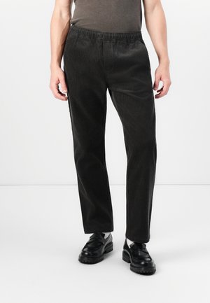 Black corduroy trousers with an elastic waistband, straight leg design, and vertical ribbed texture. Paired with black loafers.