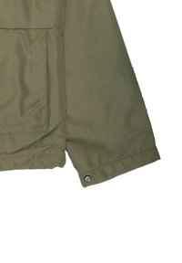 Chaqueta verde oliva con un bolsillo de solapa y un cierre a presión en el dobladillo. Fabricada con un tejido liso y duradero, presenta un diseño simple y estructurado.