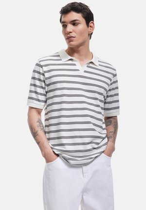 Weißes Poloshirt mit schwarzen horizontalen Streifen, kurzen Ärmeln und einem kontrastierenden Kragen. Verfügt über einen lockeren Schnitt und eine weiche Stoffoberfläche.