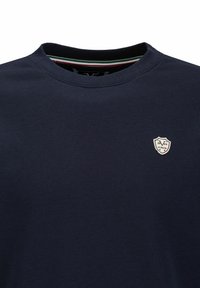 Marineblaue Baumwoll-Sweatshirt mit Rundhalsausschnitt, das ein kleines weißes Wappen-Logo mit dem Jahr "1979" sowie "Italia" in rot und schwarz zeigt.