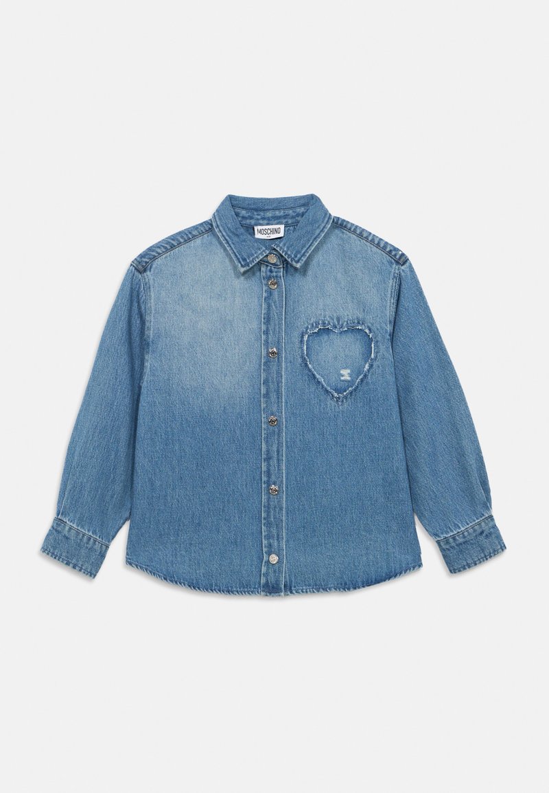 Ανοιχτό μπλε πουκάμισο από τζιν ύφασμα με κουμπιά μπροστά, μακριά μανίκια και καρδιά κομμένη στην περιοχή του στήθους. Διαθέτει αντίθετη ραφή.
