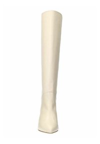 Kniehoge, puntige laars van glad crème leer met een blokhak en minimale stiksels. Platte zool en strak design.