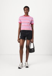 Striped pink and blue short-sleeve t-shirt, black denim shorts, silver sneakers, and a small black handbag with a logo.