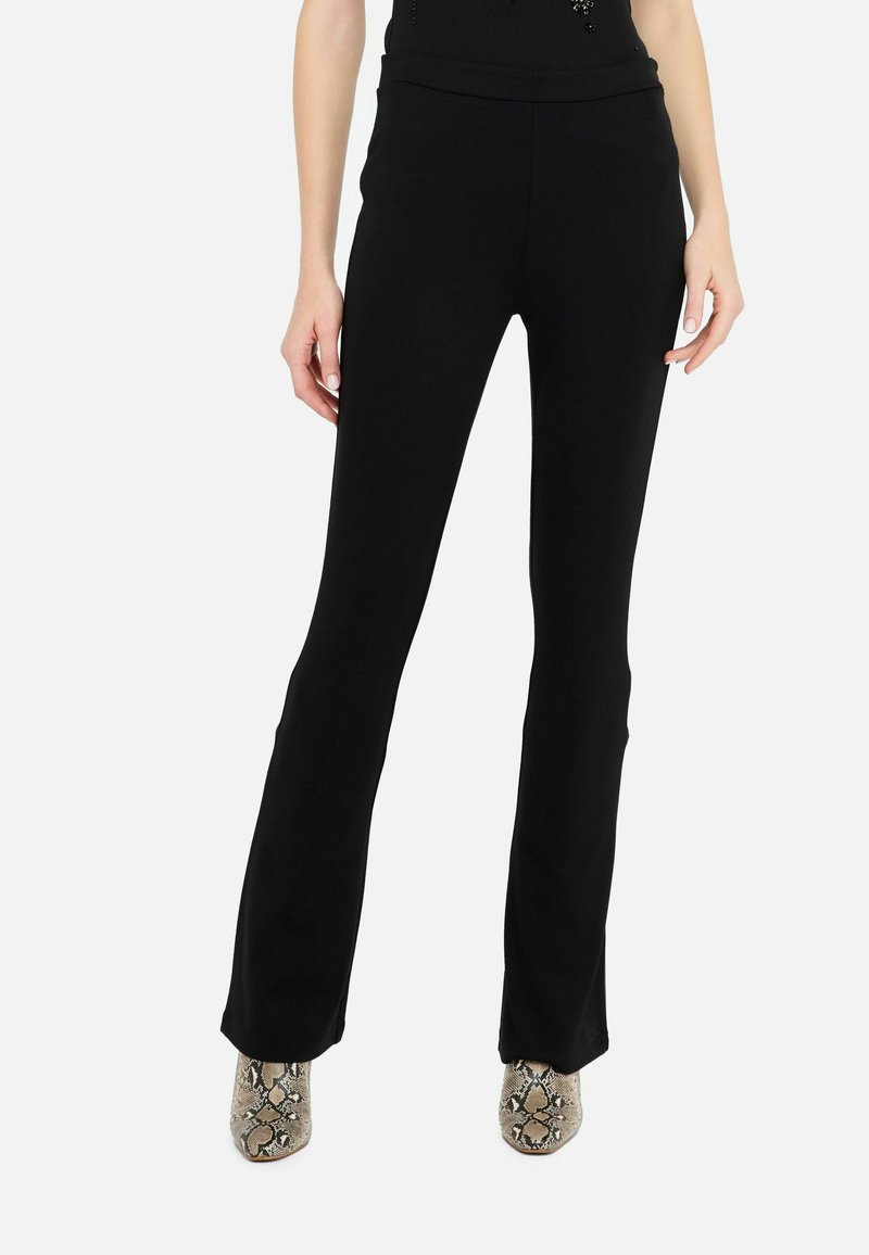 Zwarte flare-broeken met een soepele elastische tailleband. Gemaakt van rekbaar materiaal, met een slim fit bij de heupen en dijen.