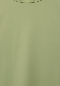 Tricou verde deschis cu guler rotund, realizat dintr-un material fin, cu o textură subtilă și o terminație fără cusături la guler.
