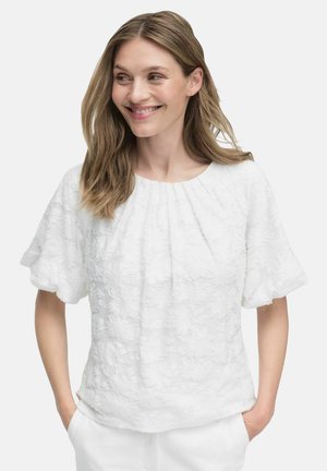 Weiße Bluse mit floralem Muster, kurzen Ärmeln und Rundhalsausschnitt, aus strukturiertem Stoff gefertigt, mit lockerer Passform und Faltendetails.