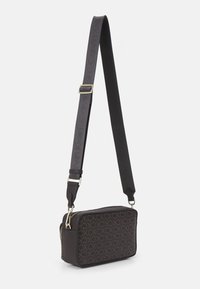 Hnědá syntetická crossbody kabelka s vzorem CK loga, obdélníkový tvar, zipové uzavření, nastavitelný popruh a zlaté kovové akcenty.