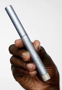 Crayon yeux argenté avec une forme cylindrique, finition mate et mécanisme de rotation. Le nom de la marque "KIKO MILANO" est visible sur le côté.