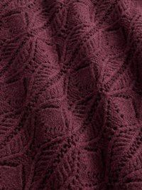 Țesătură tricotată bordo cu un model texturat în formă de frunze; material moale, asemănător lânii, cu puncte ridicate și un aspect confortabil.