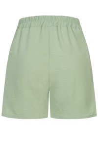 Lys grønne shorts med elastisk talje, som har en blød tekstur og et enkelt design. Ingen lommer eller synlige hardwaredetaljer.