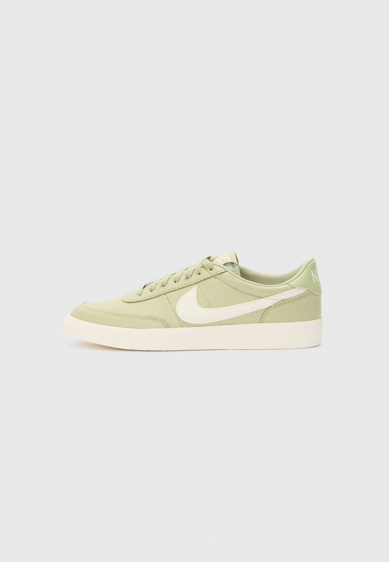 Zelene Nike tenisice s glatkom sintetičkom gornjom strukturom, bijelim swoosh logom, okruglim vrhom, ravnim gumenim potplatom i mekanim podstavljenim ovratnikom.