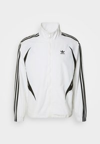 Vit jacka med svarta ränder på axlarna och sidorna, med hög krage och framdragkedja. Adidas-logotyp på vänster bröst.