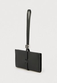 Μαύρο πορτοφόλι από δέρμα με υφή, με λεπτό σχεδιασμό, αποσπώμενο λουράκι καρπού και ασημί μεταλλικό διακοσμητικό.