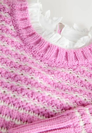 Roza i bijela prugasta debela pletiva s rebrastim ovratnikom i bijelim volanima ispod.