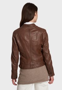 Bruine leren jas met een getailleerd ontwerp, zichtbare stiksels, ritszakken en een soepele textuur. Achteraanzicht, zonder versieringen.