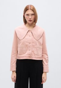 Ροζ cropped μπουφά ν με μεγάλο γιακά, κουμπιά μπροστά και δύο μπροστινές τσέπες. Κατασκευασμένο από υφή ύφασμα, διαθέτει καθαρές ραφές.