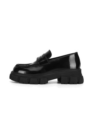 Schwarze Loafer aus Lackleder mit einer massiven schwarzen Gummisohle, versehen mit einem Mokassinfeld-Design und einem Riemen über dem Rist.