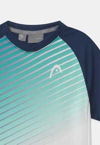 Koszulka sportowa z dekoltem w serek, z gradientowymi pasami w odcieniach teal, białym i szarym. Niebieskie rękawy i logo na panelu klatki piersiowej. Lekki materiał.