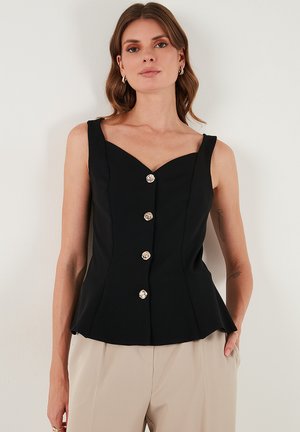 Črna brezrokavna majica s srcastim izrezom, ki ima pet kovinskih gumbov spredaj in razpečeno zaključko za oprijet silhueto.