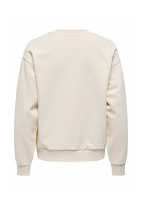 Kreemivärvi sweatshirt pikade varrukatega, ümmarguse kaelusega ja ribarega. Pehme tekstuur ilma mustrite või lisade. Puhtad, minimaalsed jooned.