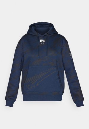 Marineblauer Hoodie mit strukturiertem Muster, Kängurutasche und Kapuze mit Zugband. Verfügt über ein weißes Logo auf der Brust und schwarze Akzente.