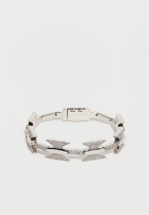 Pulsera de plata con un diseño geométrico, que presenta formas alternas de flechas pulidas y texturizadas, asegurada con un cierre.