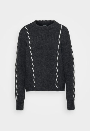 Mørkegrå genser i teksturert strikk, med hvite diagonale sømmer over kroppen og ermene. Rund hals med ribbestrikkede mansjetter og kant.