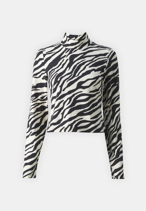 Langermet turtleneck topp med svart og kremfarget zebra-mønster, cropped design og glatt tekstur.