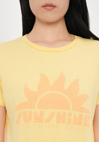 Gul bomull t-skjorte med rund hals som har et grafisk design av en sol og teksten "SUNSHINE STATE OF MIND" i lys oransje.